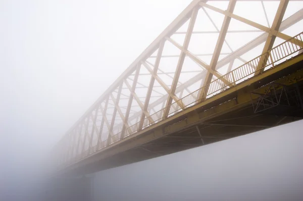 stock image Yellow bridge disappears in the thick autumn fog