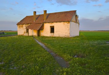 Narrow road leads to the old ruined and abandoned country house clipart