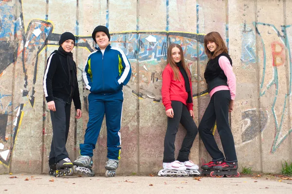 Group of teenagers going roller skating on cloudy autumn day — Stock Photo, Image