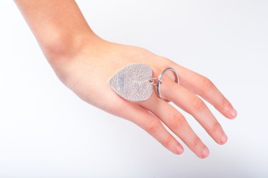 Genç parmak üzerinde kalp şeklinde metal fob