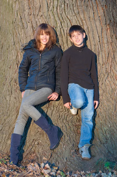 十几岁的男孩和一个女孩享受每个其他公司在阳光明媚的秋日上 — 图库照片