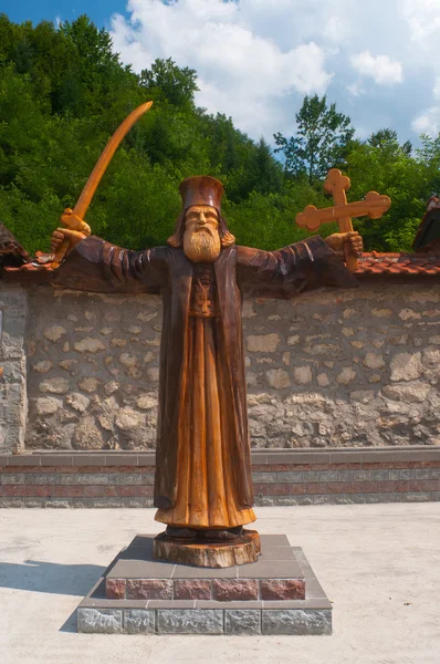 stock image Wooden sculpture showing orthodox priest holding sword in one hand