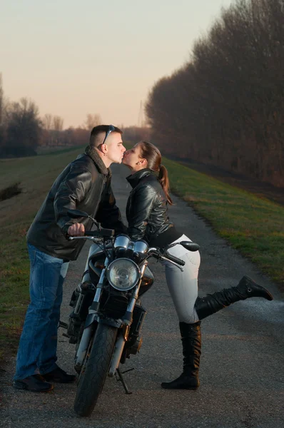 有吸引力的年轻夫妇，接吻在摩托车 — 图库照片