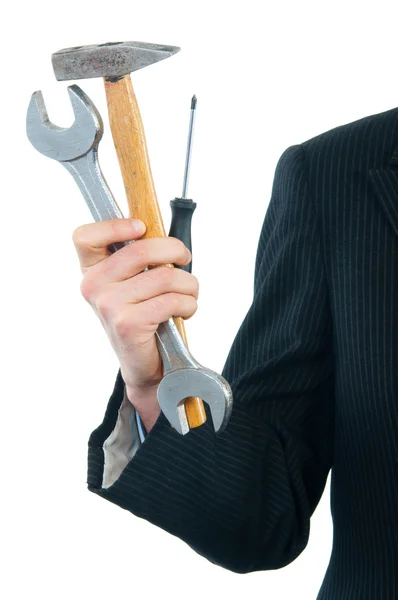Бизнесмен держит гаечный ключ, молоток и отвертку изолированы на белом . — стоковое фото