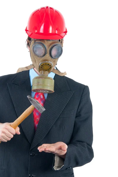 Homem de negócios com máscara de gás e capacete golpeando com martelo — Fotografia de Stock