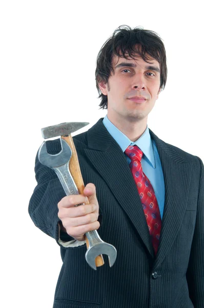 Empresário sorridente elegante distribuindo martelo e chave isoladas em branco — Fotografia de Stock