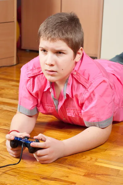 Chubby teenage boy playing computer games using game controller — Stock Photo, Image