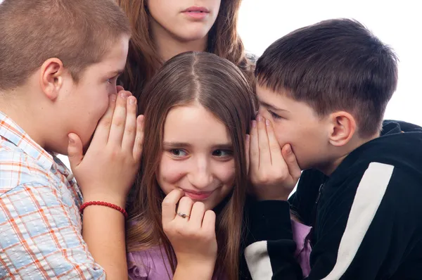 Dos chicos adolescentes y una chica adolescente chismorreando sobre su amigo mutuo w — Foto de Stock