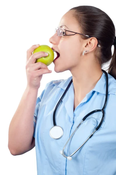 Jovem médica comendo maçã isolada em branco — Fotografia de Stock