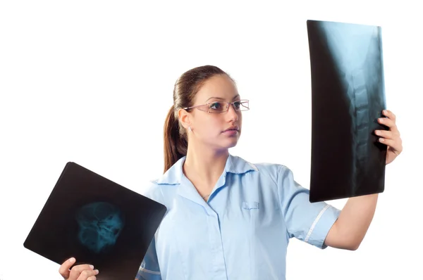 Mladý ženský lékař při pohledu na RTG snímek páteře u pacientů a lebka. — Stock fotografie