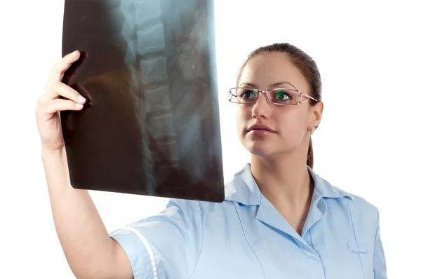 Jonge vrouwelijke arts kijken x-ray foto van patiënten wervelkolom — Stockfoto