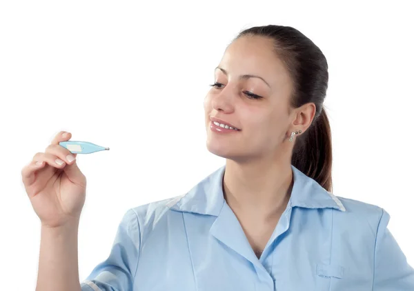Giovane sorridente medico femminile guardando il termometro isolato su bianco — Foto Stock