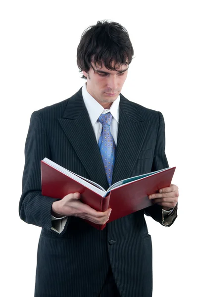 Empresário lendo o grande livro vermelho isolado em branco — Fotografia de Stock