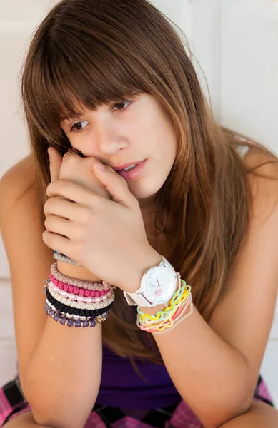 Ziemlich trauriges Teenager-Mädchen, das an einem warmen Sommertag vor der weißen Tür sitzt — Stockfoto