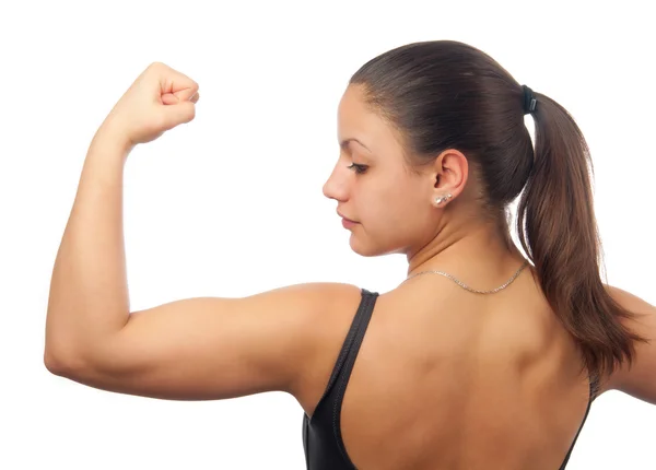 Mujer joven fuerte y musculosa mostrando sus bíceps aislados en blanco — Foto de Stock