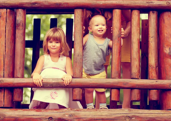 Foto em tons sépia de irmão e irmã brincando no playground — Fotografia de Stock