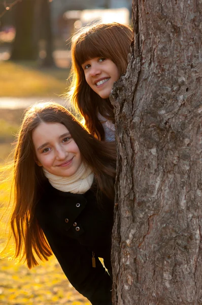 Dwie piękne dziewczyny nastoletnie zabawy w parku w słoneczny wiosenny dzień — Zdjęcie stockowe