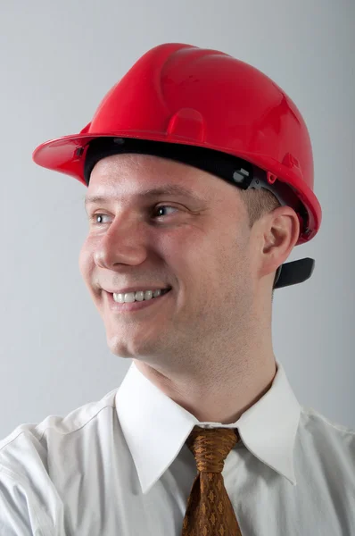 Portrait de jeune ingénieur souriant avec casque rouge — Photo