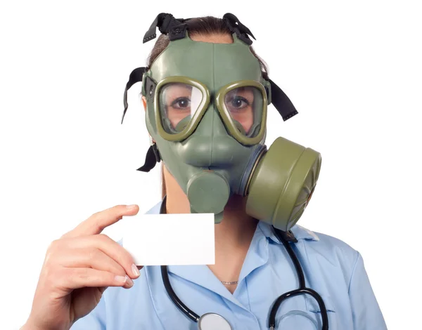 Young female doctor with stethoscope and gas mask holding business card with space for your text — Stock Photo, Image