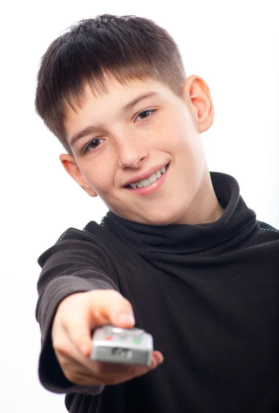 Щасливий хлопчик-підліток змінює канали на телебаченні з пультом дистанційного керування ізольовано на білому — стокове фото