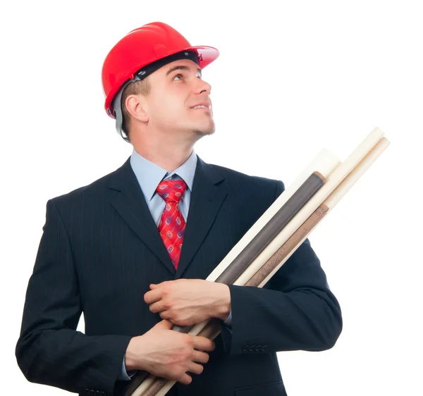 Knappe lachende ingenieur met harde hoed op zijn hoofd en blauwdrukken in zijn armen geïsoleerd op wit — Stockfoto
