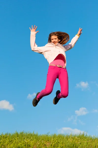 Мила дівчина-підліток стрибає з радістю в сонячний весняний день — стокове фото