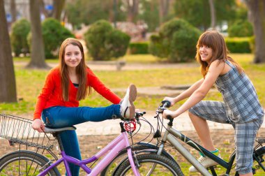 iki genç kız güzel bir bahar gününde Bisiklet Park eğlenmek güzel