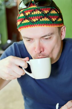 Man drinking tea or coffee clipart