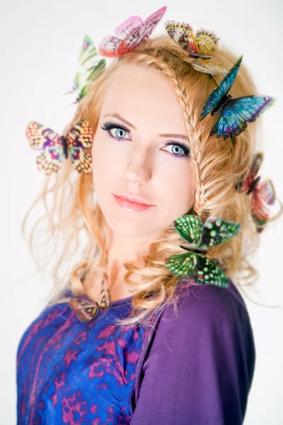 Bella donna con le farfalle nei capelli — Foto Stock