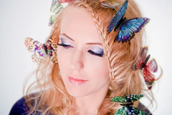 Volto di una bella donna farfalle in capelli — Foto Stock