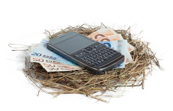 Geld und Telefon im Nest isoliert auf weiß — Stockfoto
