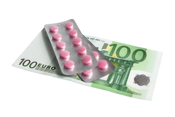 Rode pillen en 100 euro op wit wordt geïsoleerd — Stockfoto