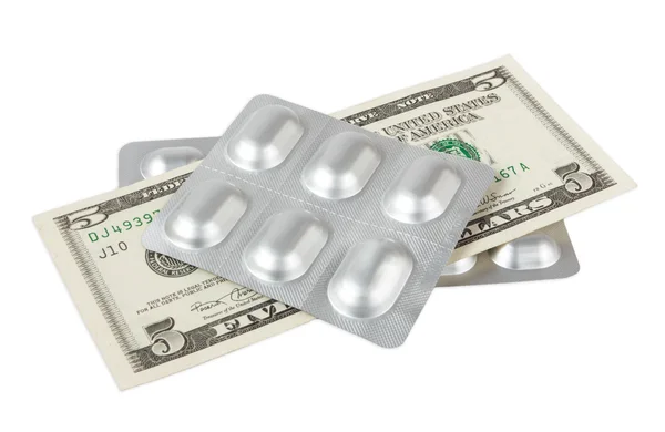 Pillen en dollar op wit wordt geïsoleerd — Stockfoto