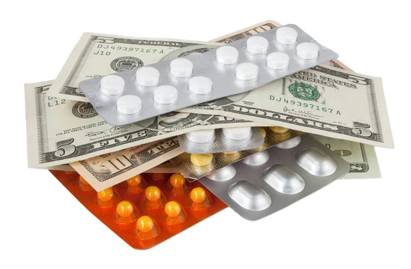 Pillen en dollars geïsoleerd op wit — Stockfoto