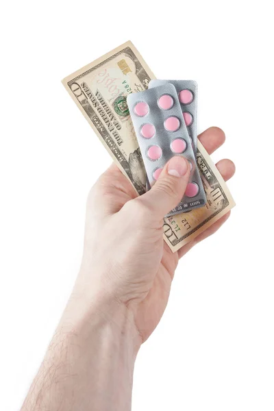 Geld und Pillen in der Hand isoliert auf weiß — Stockfoto