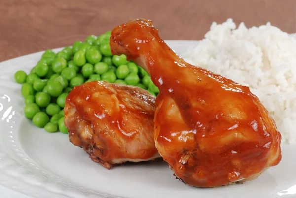 Closeup chicken leg with barbecue sauce and peas — Stock Photo, Image