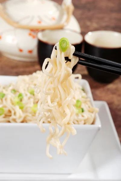 stock image Asian noodles with onions on chopsticks