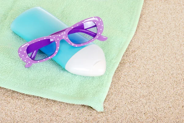 Loción bronceadora gafas de sol y toalla de playa — Foto de Stock