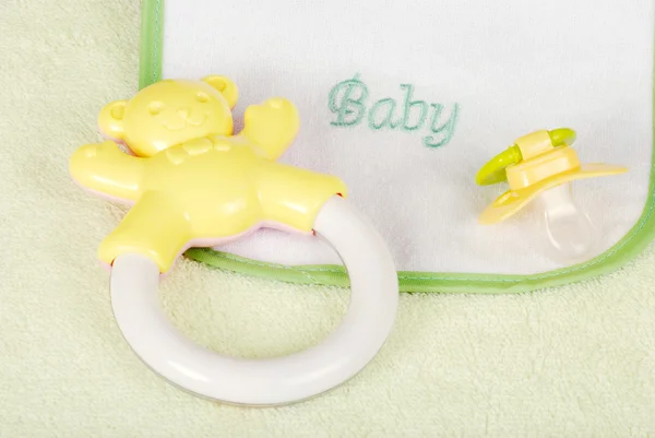 Baby rattle and bib — Stock Photo, Image