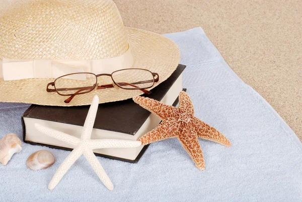 Relaxante praia conceito livro chapéu óculos — Fotografia de Stock