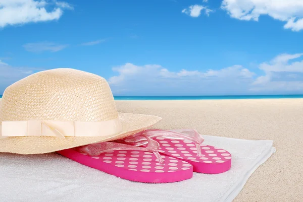 Straw hat sandals on a beach towel — Stock Photo, Image