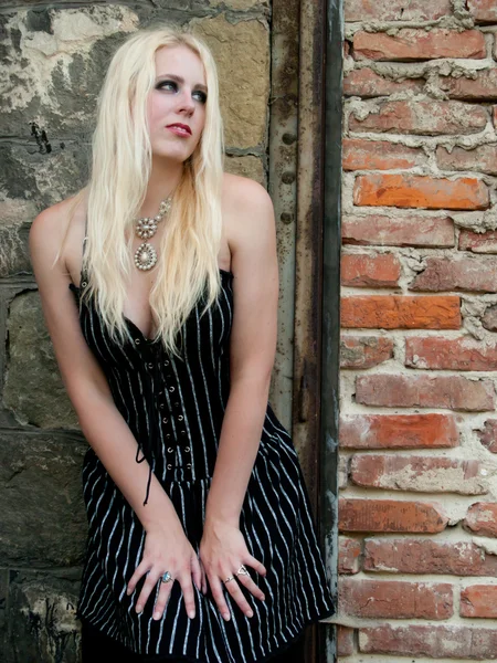 stock image Blond gothic girl in front of a brick wall