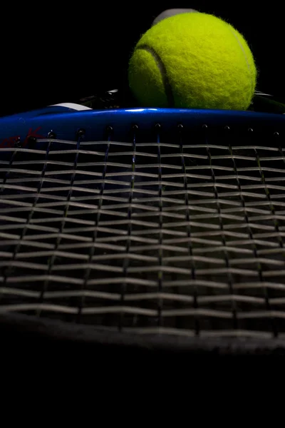 Pelota y raqueta de tenis oscuro — Foto de Stock
