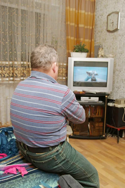 Un uomo che guarda lo schermo della sua televisione . — Foto Stock