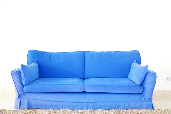 Blaues Doppelsofa an einer leeren Wand — Stockfoto