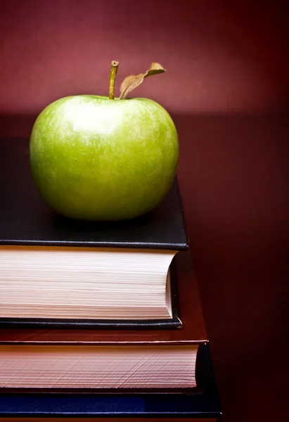 Jablko nad knihami — Stock fotografie