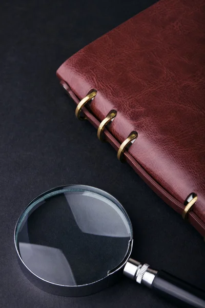Notebook with a magnifier — Stock Photo, Image