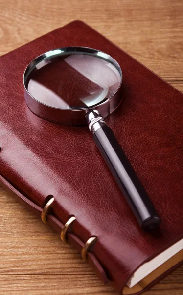 Notebook with a magnifier — Stock Photo, Image