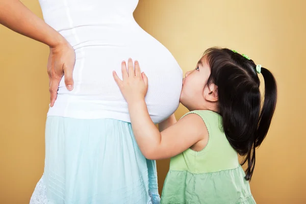 Chica besando embarazada madre —  Fotos de Stock