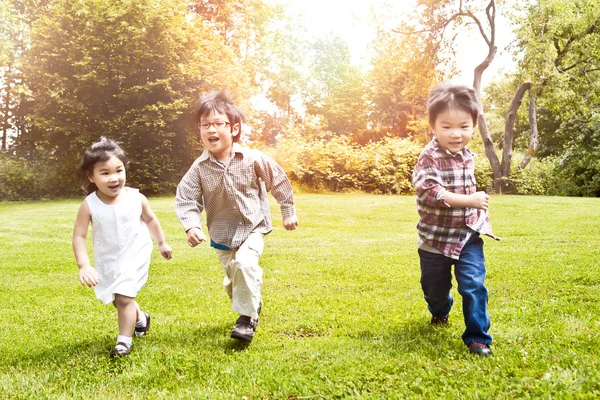 Asiatische Kinder rennen im Park — Stockfoto